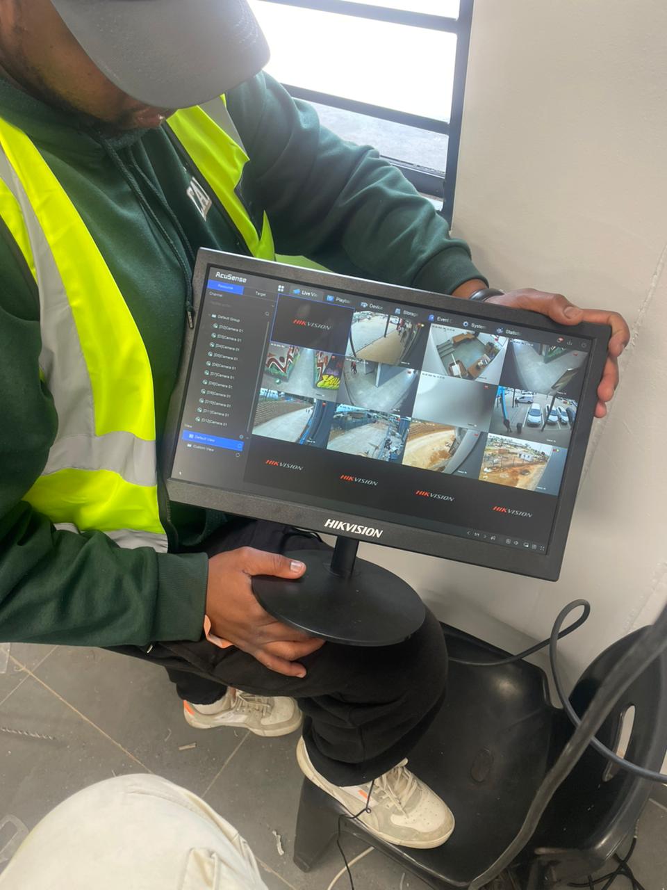 Technician checking multiple CCTV camera views on a monitor