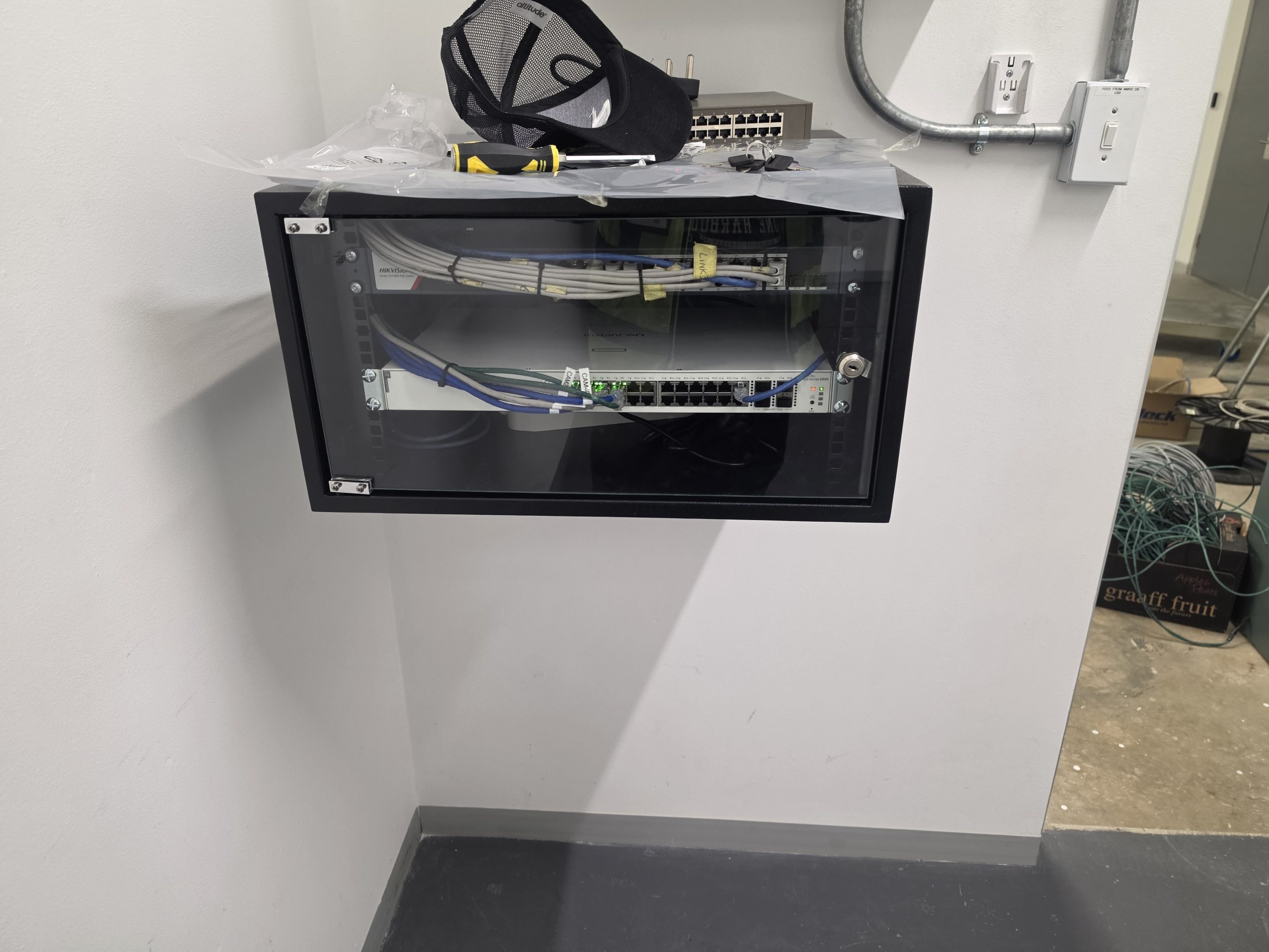 Wall mounted network cabinet with networking equipment and cable connections
