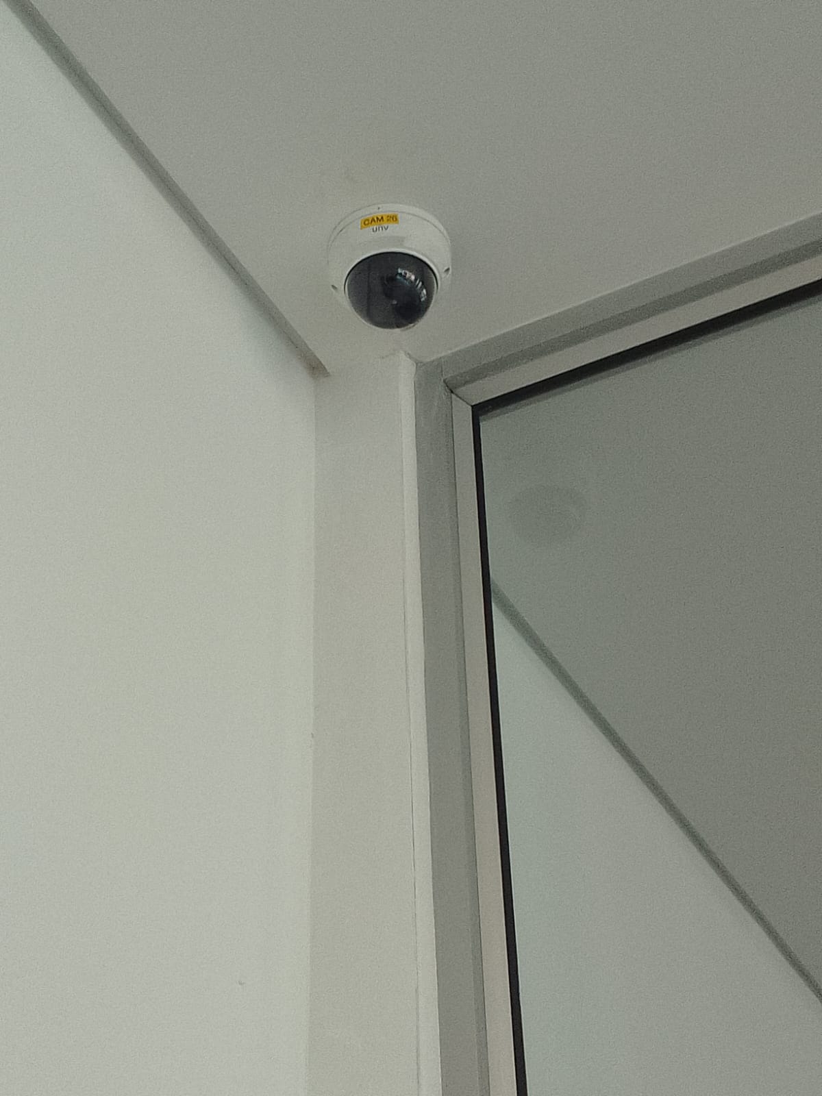 Dome CCTV camera mounted above a glazed doorway