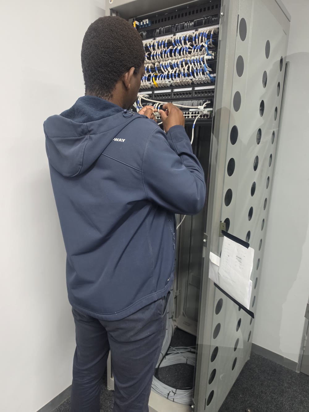 Technician patching a labelled network cabinet